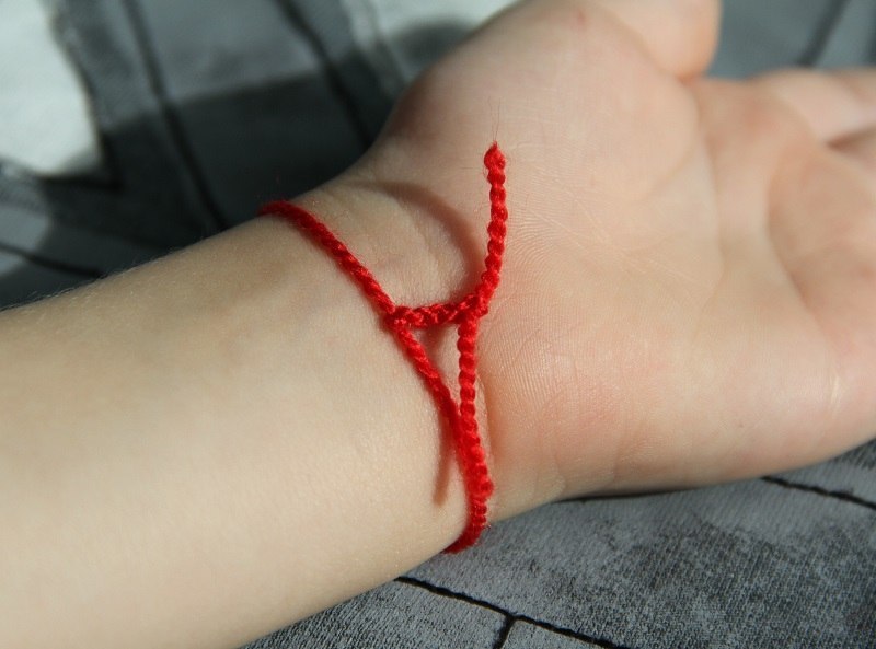 Завязанные нитки на руке. Красная нить на руке. Красная нитка на руке. Красная шерстяная нить.