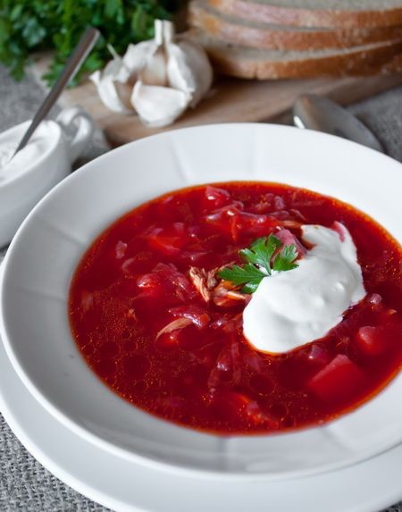 С праздником!😄

У каждой итальянки есть свои секреты приготовления пиццы и лазаньи, у француженки — киша с грибами и шпинатом, петуха в вине и рататуя. Рецепты этих национальных блюд варьируются в зависимости от региона проживания хозяйки и семейных традиций. Это же утверждение применимо и к борщу, появившемуся на Руси примерно в X-XII вв. Рецепт культового блюда, которые подавали даже на поминках, переняли, серьёзно изменив, молдаване, поляки, евреи-ашкеназы и представители других народностей.

На Руси не существовало общих гастрономических традиций приготовления борща — отвара из съедобной разновидности борщевика. Кроме его побегов и листьев, в похлёбку клали квашеную свёклу или капусту, крапиву и другие дикорастущие травы. Великорусский борщ готовили на основе говяжьего бульона, подавали со ржаным хлебом.

По старинным украинским рецептам его делали на печёной свекле со свекольным квасом (сыровцом) для придания остроты вкусу и добавляли просо. Если стряпухи из Малороссии клали в блюдо капусту, то сырую и в самом конце приготовления, а не квашеную. К борщу, приготовленному на свином бульоне, они подавали пампушки с чесноком и сметану.

В Таганроге с момента прихода в порт кораблей с заморскими помидорами в рецепте появились томаты и фасоль. Тогда же к ним добавился и картофель. В 1920-1930 гг. свёклу, которая не является морозоустойчивой культурой, на севере России стали всё чаще заменять капустой. А в советское время появилась традиция приготовления зажарки на томатной пасте.

Белорусские хозяйки не кладут в борщ капусту, заменяя варёной в кожуре свёклой и зеленью. Существует множество рецептов любимого миллионами блюда, которое стало визитной карточкой национальной кухни восточных славян.

Каждый год 10 ноября отмечается День борща. В честь праздника в России, Беларуси и Украине проводятся гастрономические фестивали с конкурсами, мастер-классами и другими мероприятиями. Рецепт борща издавна варьировался в зависимости от места приготовления и времени года.

На флоте в блюдо на основе крепкого бульона добавляли бекон и другие копчёности, приправляя жгучим перцем. Весной, когда на огороде появляются первые побеги щавеля, шпината, укропа и зелёного лука, хозяйки делают зелёный борщ с добавкой варёного яйца. Летом в состав блюда по классическому рецепту включают не только клубни, но и молодую свёклу вместе с листьями и стеблями. Сколько хозяек, столько и борщей. Так гласит известная пословица. Борщ бывает разным: постным или на мясном наваристом бульоне, красным или зелёным, со шкварками и салом с чесноком или без них.

Невзирая на традиции приготовления, блюдо неизменно пользуется успехом у гостей и хозяев дома. День борща — отличный повод вспомнить хлебосольные традиции славян, собравшись с членами семьи и друзьями за щедро накрытым обеденным столом.